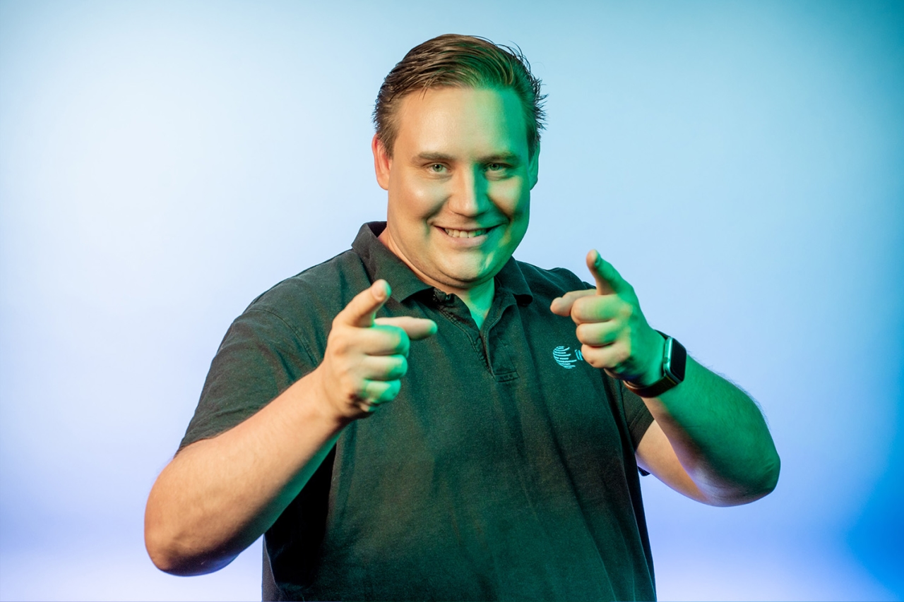 Hombre sonriendo y señalando con ambos dedos a la cámara