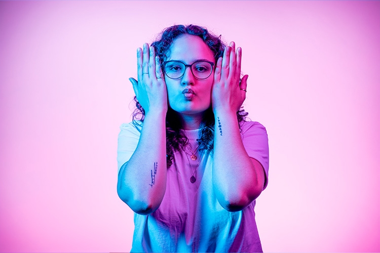 Mujer hace boca de pez y se lleva las manos a la cara